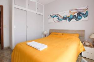 1 dormitorio con 1 cama con colcha amarilla en Piso Del Mar Menor, en Los Nietos