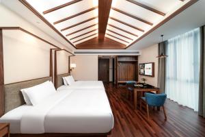 佛山市にあるSSAW Boutique Hotel Foshan Qiandeng Lakeのベッド2台と机があるホテルの部屋