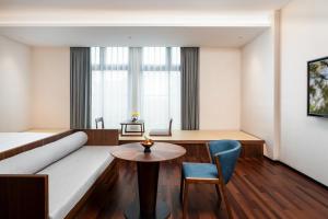 佛山市にあるSSAW Boutique Hotel Foshan Qiandeng Lakeのソファとテーブルのあるリビングルーム