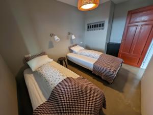 2 camas en una habitación con puerta en Hótel Hrífunes en Hrífunes 