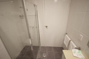 a shower with a glass door in a bathroom at Albury Paddlesteamer Motel in Albury