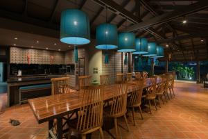 un ristorante con tavoli e sedie in legno e luci blu di Anchan Boutique Resort and Spa a Ban Thalat Choeng Thale