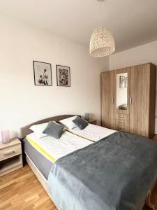 a bedroom with a large bed and a chandelier at City Break Apartment in Visoko