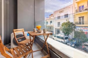 アテネにあるAthenian boutique apartmentsの通りの景色を望むバルコニー(テーブル、椅子付)