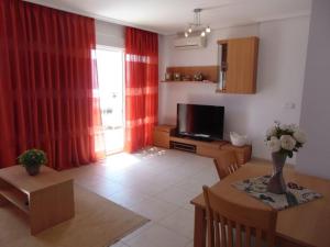 a living room with a dining table and a television at Marina d’Or Beachfront-Vista al mar frontal in Oropesa del Mar