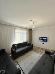 a living room with a couch and a tv at Öztürk VIP in Pelitli