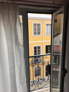 リスボンにあるVictoria Placeの窓から黄色い建物を望む