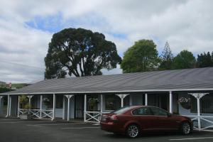 a car parked in front of a house at Accommodation at Te Puna Motel in Tauranga