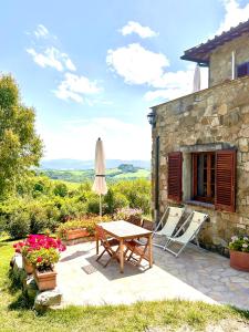 蒙泰卡蒂尼瓦爾迪切奇納的住宿－Relais Poggio Del Melograno，庭院配有桌椅和遮阳伞。