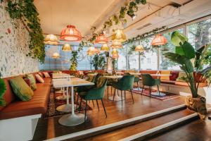 a restaurant with tables and chairs and potted plants at Hotel Daniel Vienna - Smart Lifestyle Near City Centre in Vienna