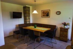 a dining room with a wooden table and chairs at Ferienwohnung SandSteinLand in Reinhardtsdorf