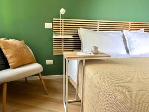 a bedroom with a bed with a table and a chair at Una finestra sul parco in Bergamo