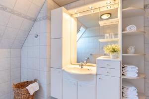 y baño con lavabo y espejo. en alkoven, en Oldsum