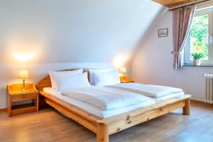 1 dormitorio con cama de madera con sábanas blancas y ventana en alkoven, en Oldsum