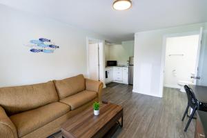 Anchor Bay Inn and Suites في ساندسكاي: غرفة معيشة مع أريكة وطاولة