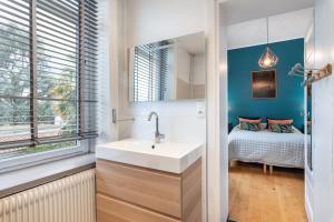 un bagno con lavandino e una camera da letto con un letto di Louisiane- House with swimming pool a Écully Altre 31 foto