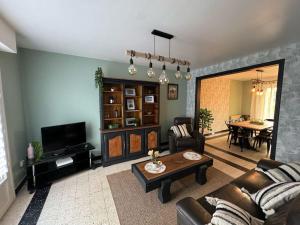 a living room with a couch and a table at The House of the 47ème in Port-en-Bessin-Huppain +36 photos