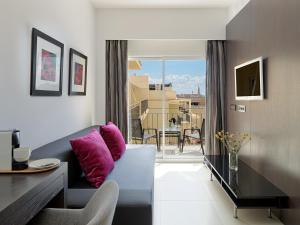 sala de estar con sofá y almohadas moradas en Hotel Saratoga en Palma de Mallorca