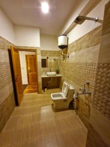 a bathroom with a toilet and a sink at THE LANDSBY COTTAGES in Nagar