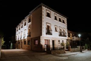 un gran edificio blanco por la noche en Apartamentos Boutique Heritage, en San Martín de Trevejo