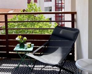 a black chair sitting on a balcony with a table at Pays Basque Ciboure - calme, port & plages à pied in Ciboure