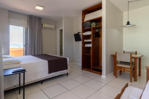 a bedroom with a bed and a table and a chair at Rio Branco Hotel in Florianópolis +55 photos