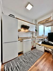 cocina con electrodomésticos blancos y alfombra blanca y negra en Sabino Street Apartment, en Santa Cruz de Tenerife