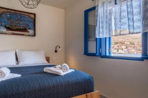 1 dormitorio con 1 cama con toallas en Porphyra Studio en Halki