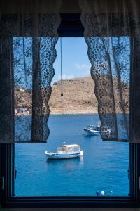 due barche in acqua attraverso una finestra di Porphyra Studio a Calchi (Halki)