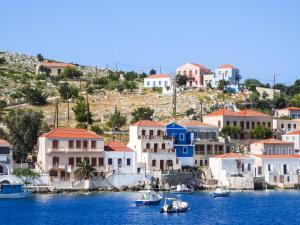 a group of houses and boats in the water at Porphyra Studio in Halki
