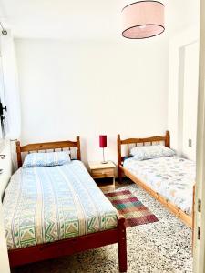 a bedroom with two beds and a table with a lamp at Le mont canigou in Taurinya