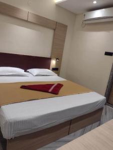 Hotel Skyking في Gauripur: غرفة نوم بسرير عليها منديل احمر