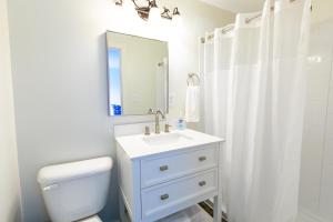 La salle de bains est pourvue d'un lavabo, de toilettes et d'un miroir. dans l'établissement Anchor Bay Inn and Suites, à Sandusky