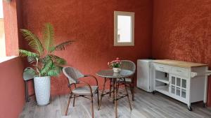 uma sala de jantar com mesa e cadeiras e uma planta em chambre d'hôte cosy em Carbuccia