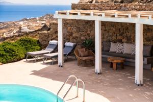 a patio with a couch and chairs next to a pool at Velanos Villa in Plintri
