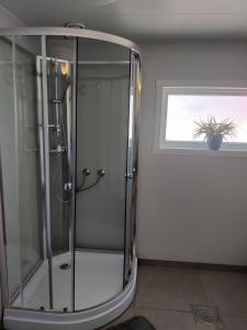 a glass shower in a bathroom with a window at FeelHome 4 bedrooms apartment Polarvegen in Tromsø