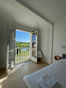a bedroom with a bed and a balcony with a view at Résidence L'Oustal Del Carlat in Carla-Bayle