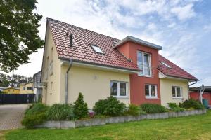 ein Haus mit rotem Dach in der Unterkunft Haus Neuhof 01 in Heringsdorf