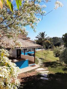 a house with a porch with a blue pool at Sítio em Sabará-Ravena com Piscina e internet rápida in Sabará