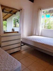 a bedroom with two beds and a window at Sítio em Sabará-Ravena com Piscina e internet rápida in Sabará +31 photos
