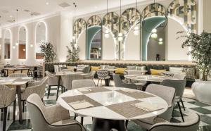 un restaurante con mesas y sillas en una habitación en Ilunion Les Corts Spa en Barcelona