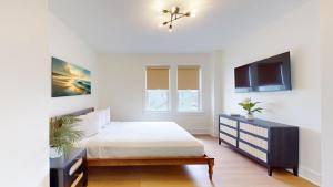 1 dormitorio blanco con 1 cama y TV en The Cove, en Ocean City