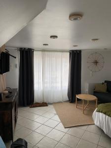 - un salon avec un lit et une fenêtre dans l'établissement appart studio complet RDC de maison avec extérieur, à Tinqueux