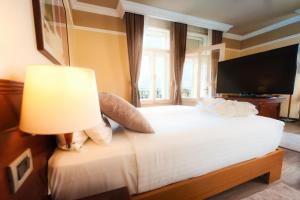 a bedroom with a white bed with a large window at BRISTOL Hotel Opatija in Opatija