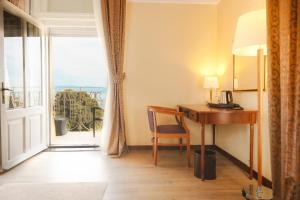 Habitación con escritorio y ventana con vistas. en BRISTOL Hotel Opatija en Opatija