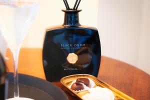 a bottle of black oil sitting on a table with a tray of desserts at BRISTOL Hotel Opatija in Opatija