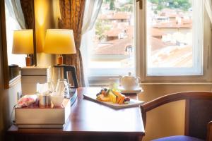 a table with a plate of food on it with a window at BRISTOL Hotel Opatija in Opatija
