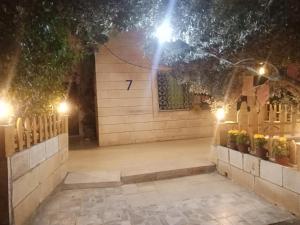 un patio nocturno con luces en la pared en Flower 2, en Jerash