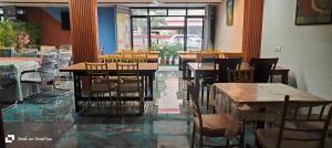 Un restaurante con mesas y sillas en una sala. en Hotel Jubilant Stays, en Bangalore