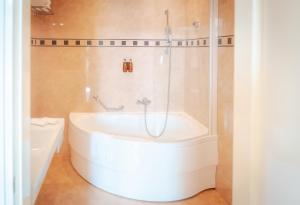 a white bath tub in a bathroom with a shower at BRISTOL Hotel Opatija in Opatija